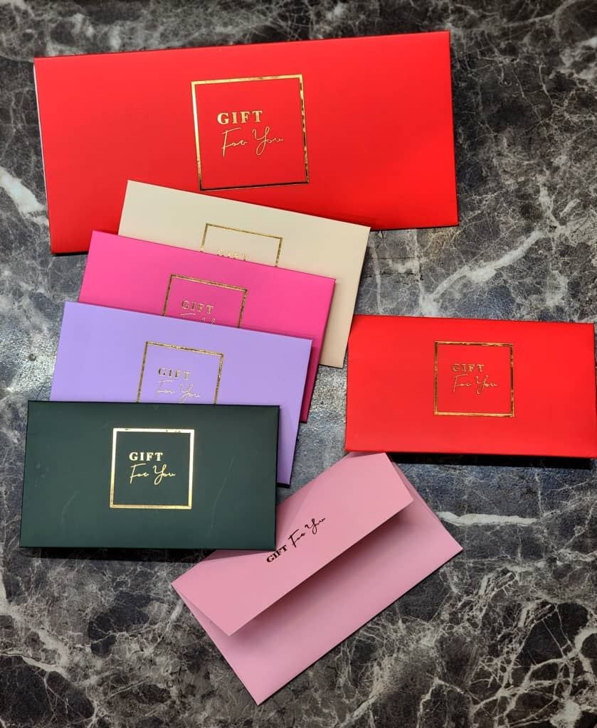 پاکت سکه پاستیلی مجموعه‌ای از **باکس‌های کادو لوکس** با طرح "GIFT For You" و کادر طلایی. دارای رنگ‌بندی متنوع و جذاب، ایده‌آل برای بسته‌بندی شیک و رسمی انواع هدایا. جین ۱۲عددی می‌باشد
